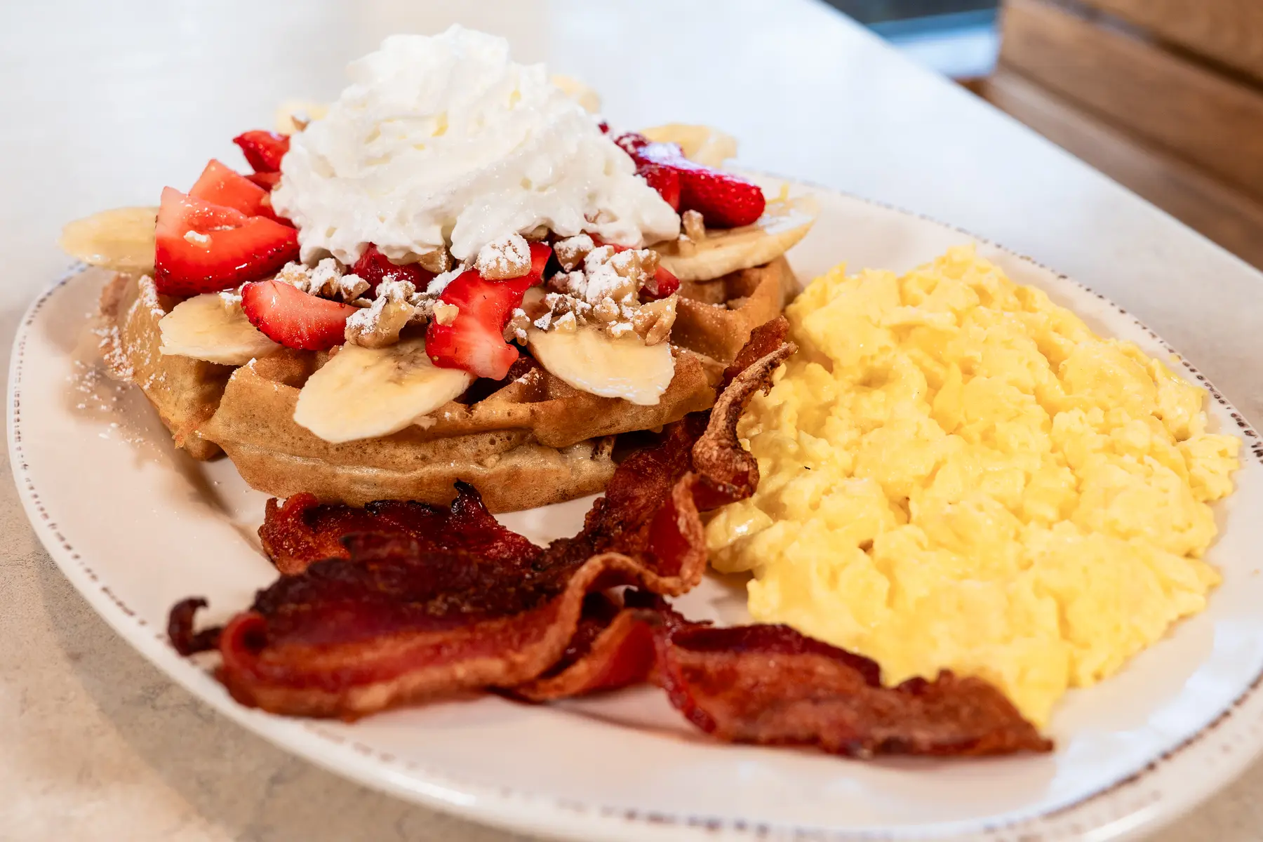 Strawberry waffle, eggs, and bacon at The Egg